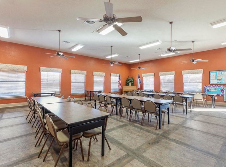 Clubhouse meeting room with tables, chairs, and orange walls